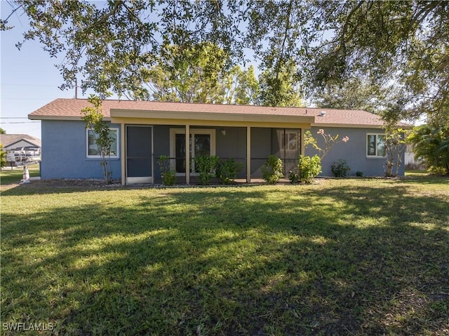 back of house featuring a sunroom and a lawn