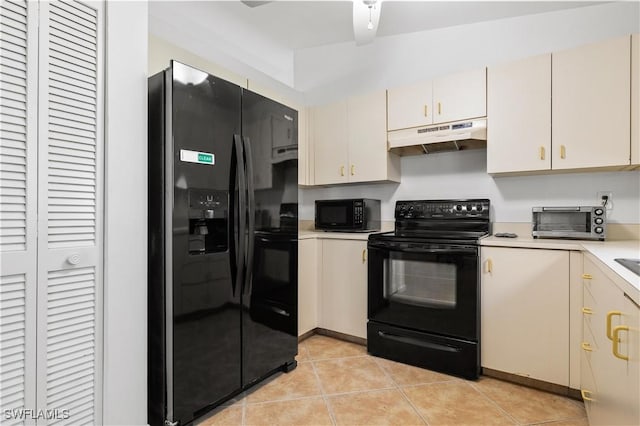 kitchen featuring light tile patterned flooring, cream cabinetry, and black appliances