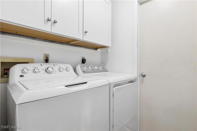 laundry area featuring washer and dryer and cabinets