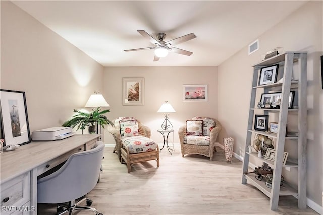 office with light wood-type flooring and ceiling fan