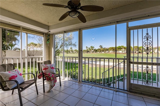 unfurnished sunroom with ceiling fan