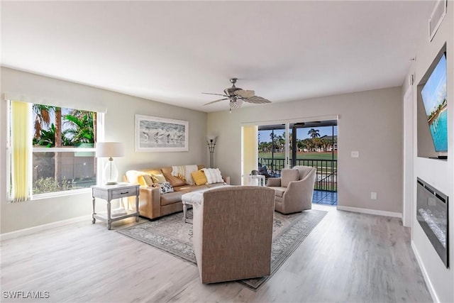 living room with ceiling fan and light hardwood / wood-style flooring