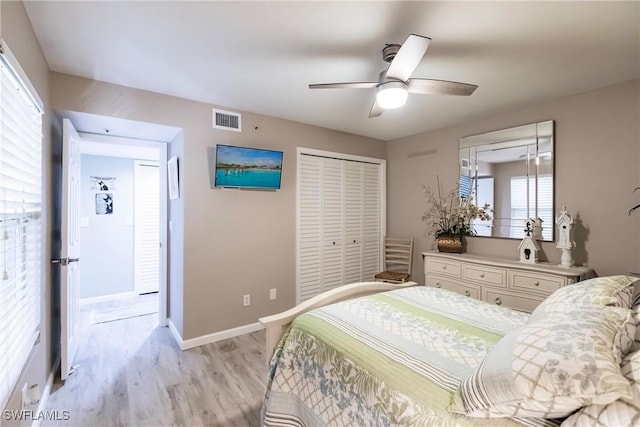 bedroom with multiple windows, a closet, light hardwood / wood-style flooring, and ceiling fan