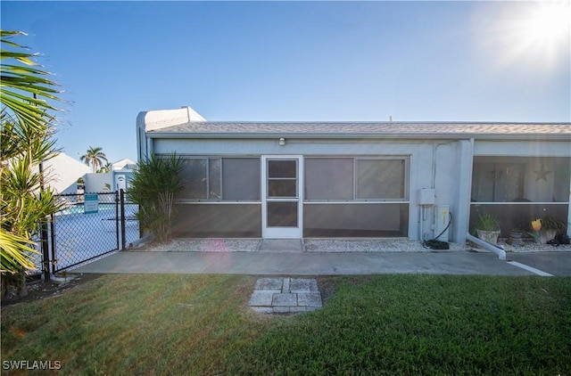 back of house with a sunroom and a yard