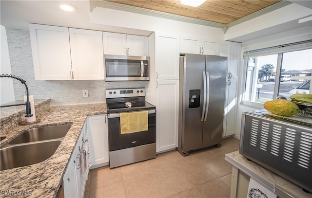 kitchen featuring decorative backsplash, appliances with stainless steel finishes, light stone counters, sink, and white cabinetry