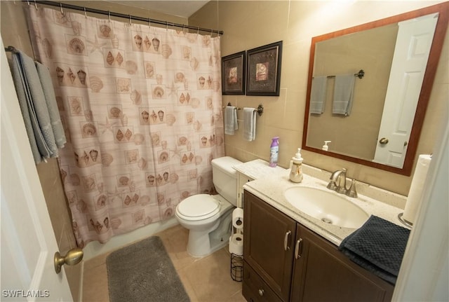 bathroom with tile patterned floors, toilet, vanity, and walk in shower