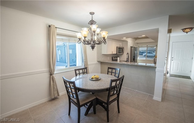 dining space featuring a notable chandelier and light tile patterned floors