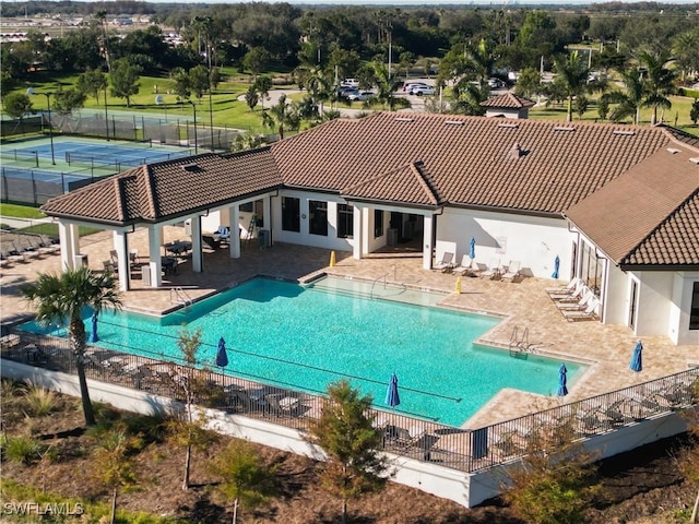 view of pool with a patio area and tennis court