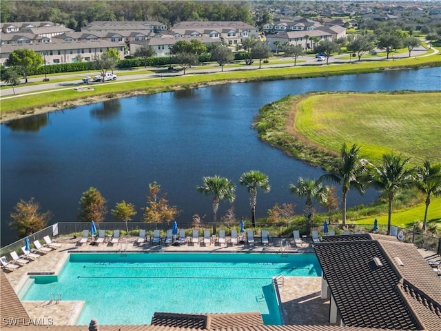 view of pool with a lawn and a water view