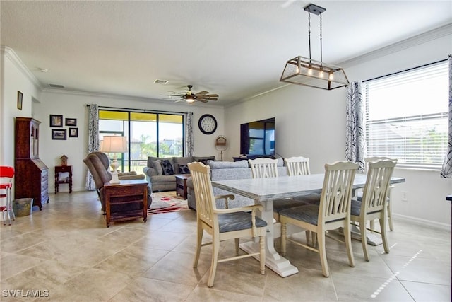 dining space with light tile patterned floors, ceiling fan, and ornamental molding