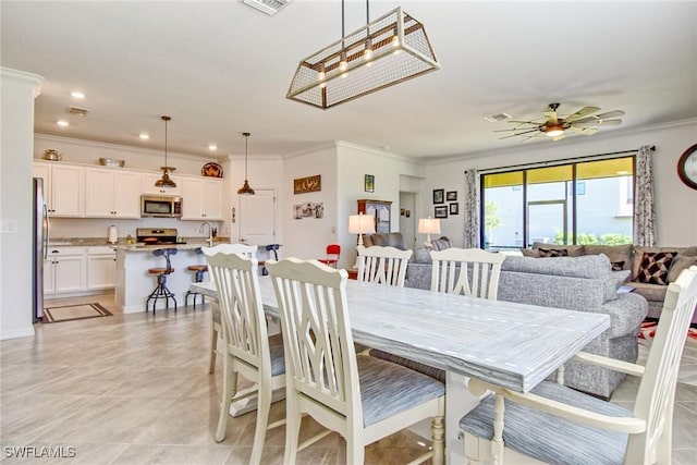 dining space featuring ceiling fan, light tile patterned floors, and ornamental molding