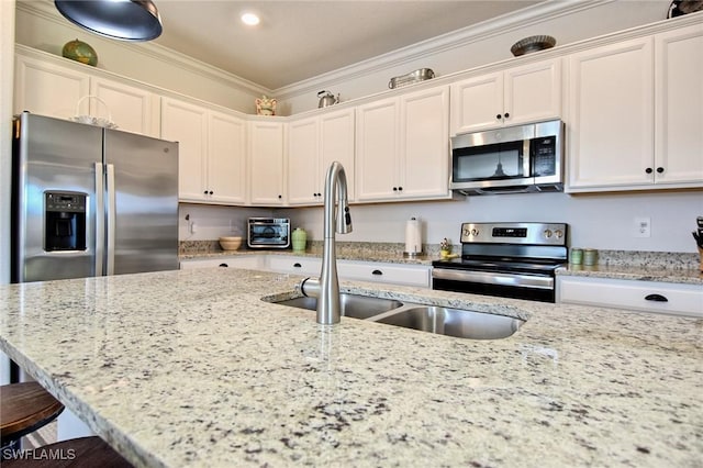 kitchen with sink, ornamental molding, appliances with stainless steel finishes, light stone counters, and white cabinetry