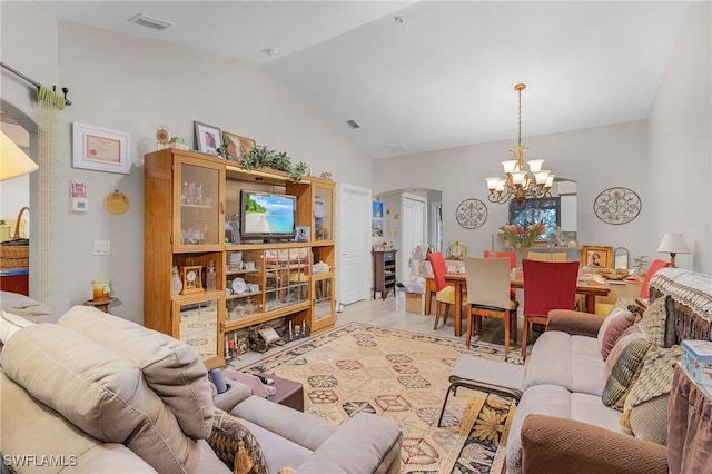 living room with light hardwood / wood-style floors, lofted ceiling, and a notable chandelier