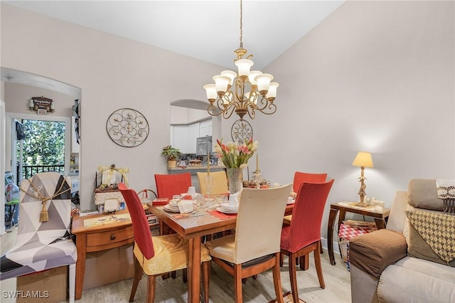 dining room featuring a chandelier, light wood-type flooring, and lofted ceiling