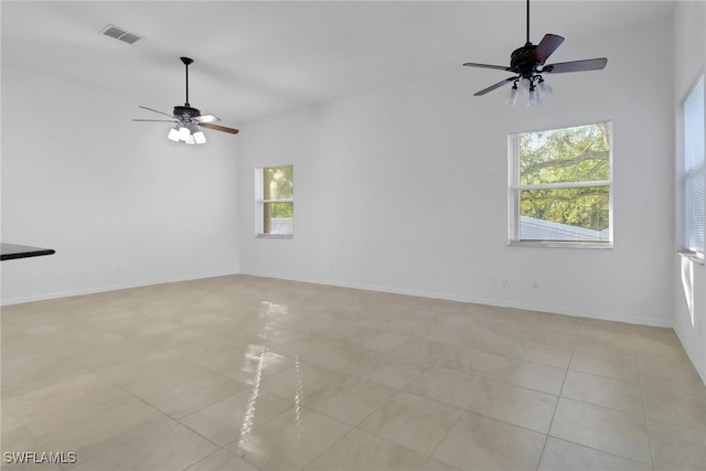 tiled empty room featuring ceiling fan