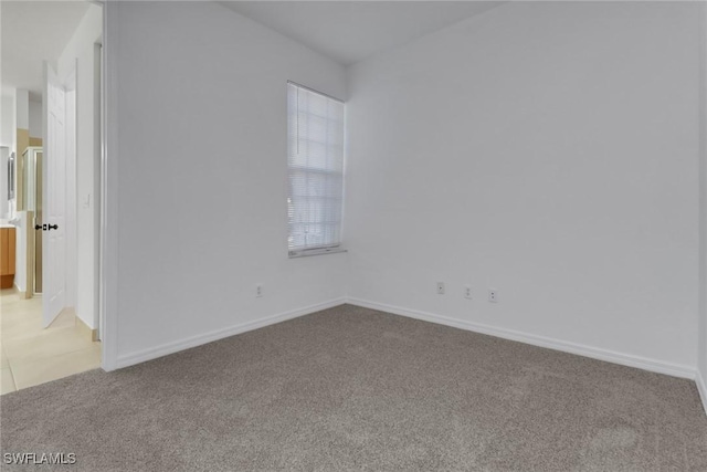 spare room featuring light colored carpet