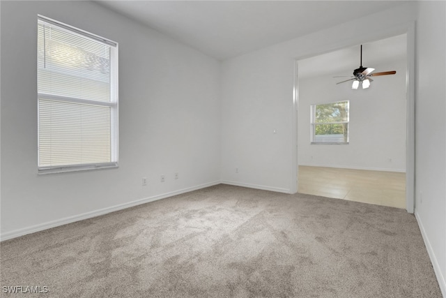 carpeted spare room with ceiling fan