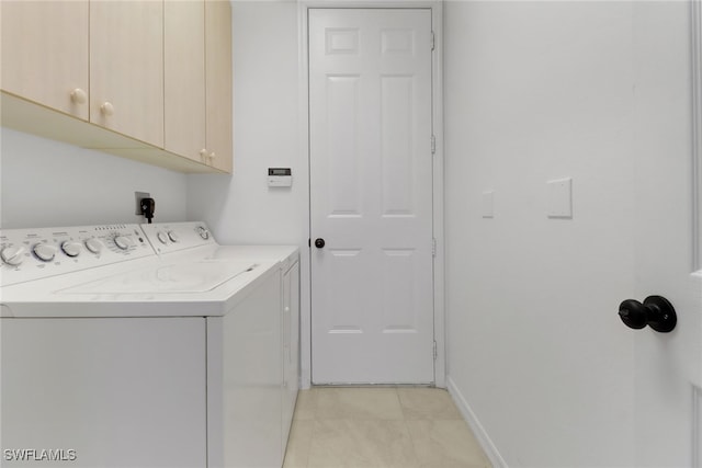 laundry area with cabinets, separate washer and dryer, and light tile patterned flooring