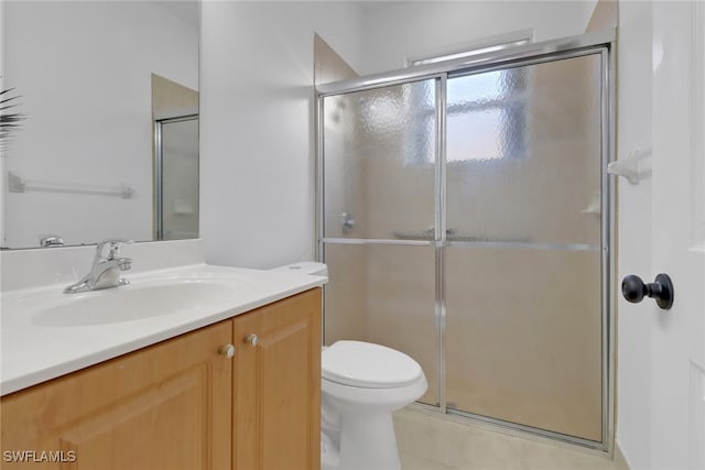 bathroom featuring vanity, an enclosed shower, and toilet