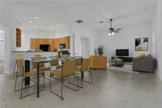 dining room with ceiling fan and a towering ceiling