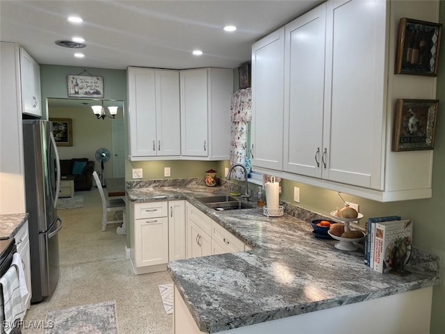 kitchen featuring kitchen peninsula, stainless steel fridge, sink, white cabinets, and range