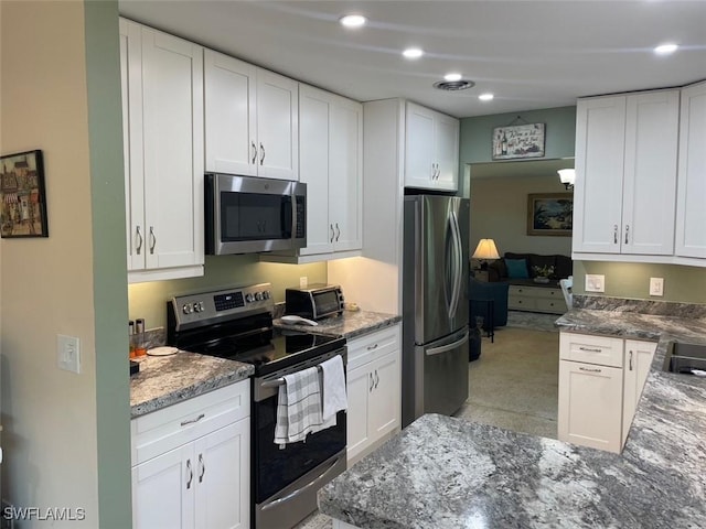 kitchen featuring kitchen peninsula, white cabinetry, and stainless steel appliances