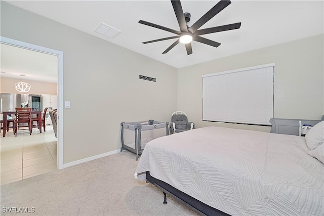 carpeted bedroom with stainless steel fridge and ceiling fan