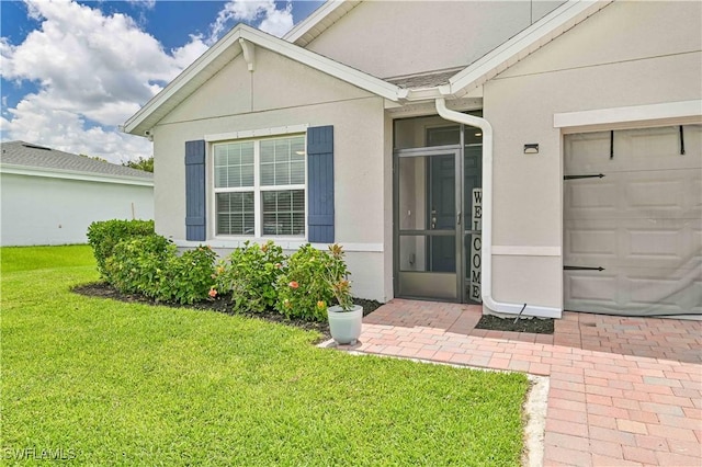 property entrance with a yard and a garage