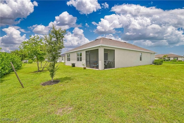 back of house featuring a yard and a sunroom