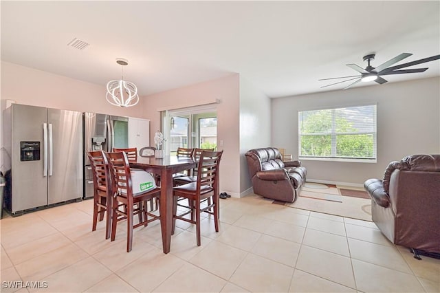 dining space featuring light tile patterned floors, ceiling fan with notable chandelier, and a wealth of natural light