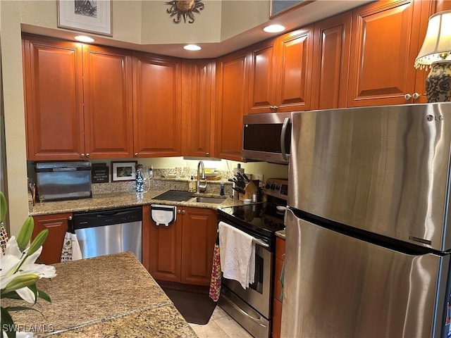 kitchen with light stone countertops, sink, and appliances with stainless steel finishes