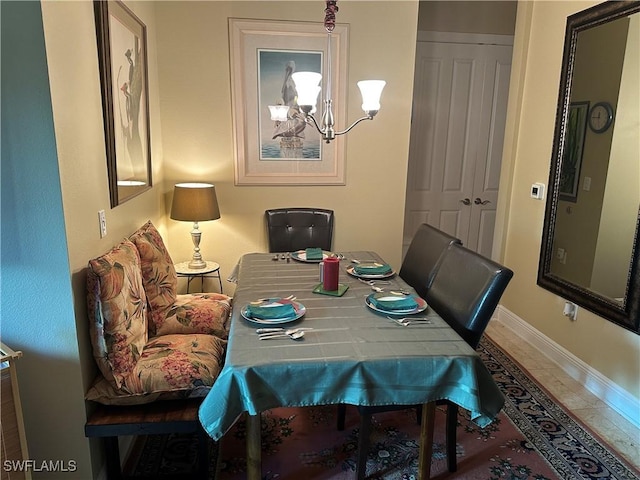 tiled dining area featuring a chandelier