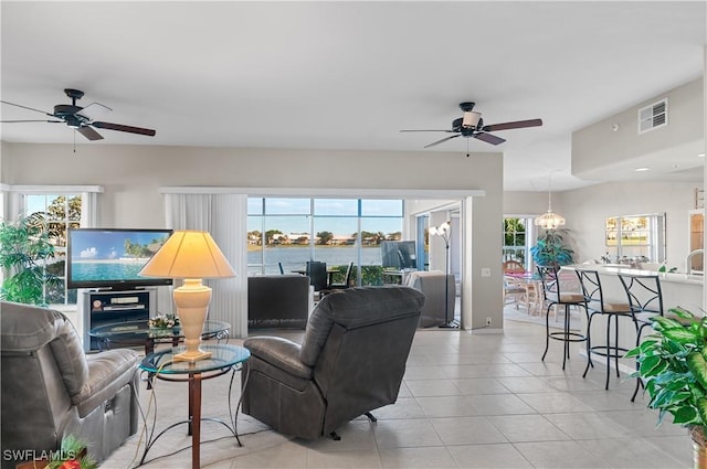 living room with light tile patterned floors, plenty of natural light, and ceiling fan