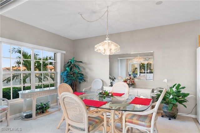 carpeted dining space with an inviting chandelier