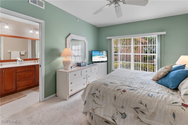 bedroom featuring ensuite bathroom, ceiling fan, and light carpet