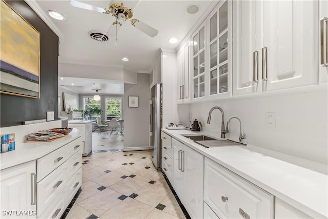 kitchen featuring white cabinetry, sink, ceiling fan, and ornamental molding