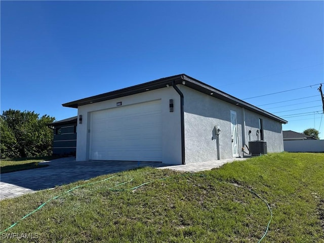 view of home's exterior with a garage, a yard, and central AC