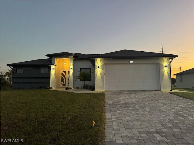 view of front of property featuring a yard and a garage