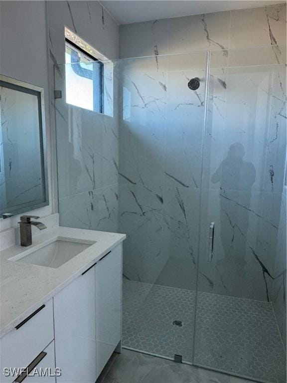 bathroom with vanity and a shower with door