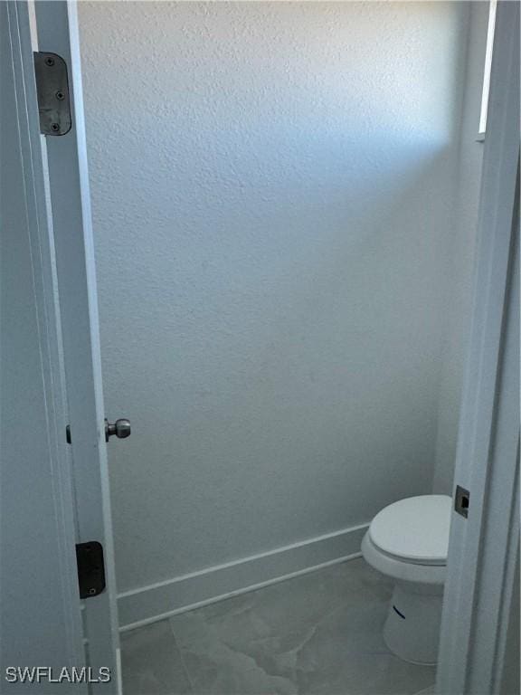 bathroom with tile patterned flooring and toilet