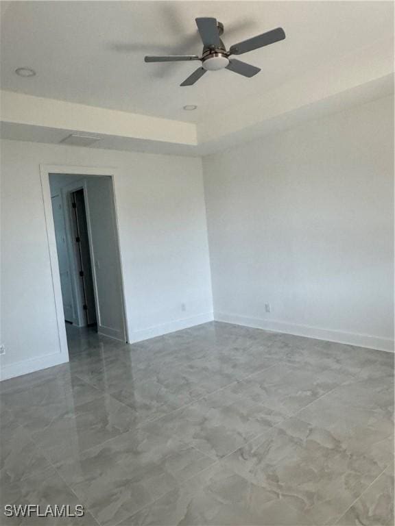 spare room featuring ceiling fan and a tray ceiling