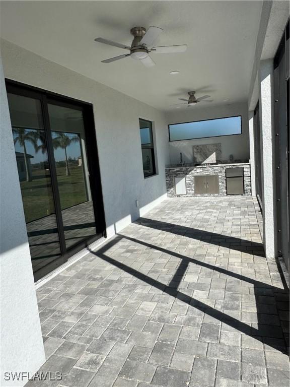 view of patio / terrace with ceiling fan and exterior kitchen