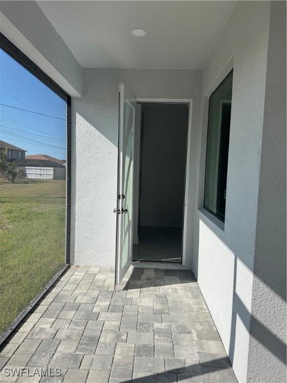 property entrance with a yard and a patio