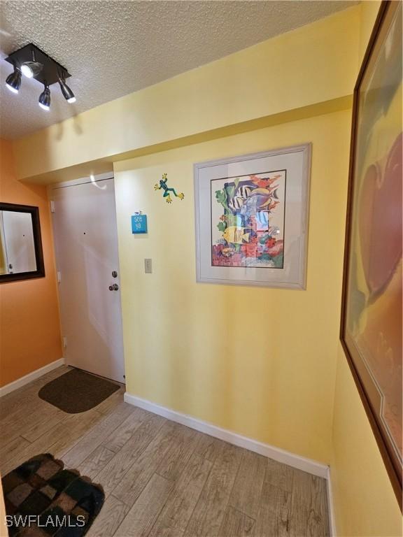 interior space with a textured ceiling and light wood-type flooring