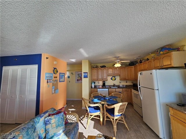 kitchen with sink, white appliances, ceiling fan, a textured ceiling, and light wood-type flooring