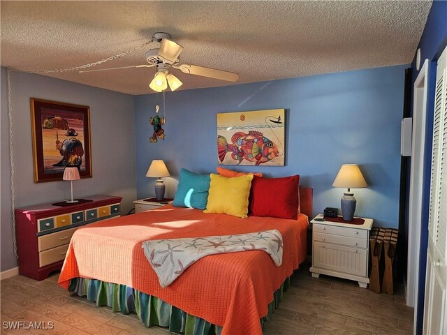 bedroom featuring ceiling fan, dark hardwood / wood-style floors, and a textured ceiling