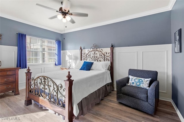 bedroom featuring hardwood / wood-style flooring, ceiling fan, and crown molding