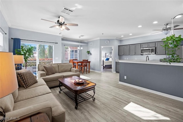 living room with ceiling fan, light hardwood / wood-style floors, and ornamental molding