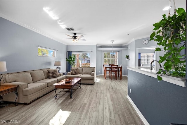 living room featuring light hardwood / wood-style flooring, ceiling fan, and ornamental molding