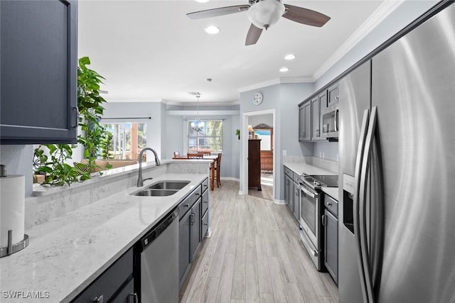 kitchen featuring pendant lighting, crown molding, sink, and appliances with stainless steel finishes